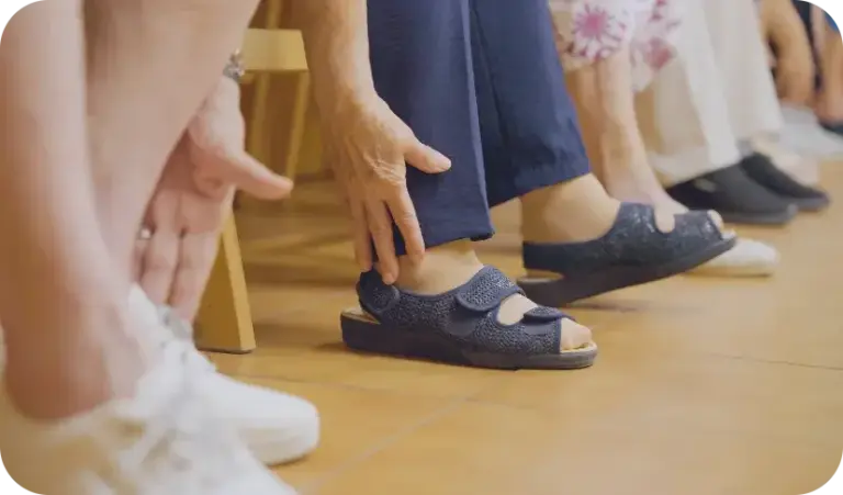 Personas mayores tocando sus pies con la mano